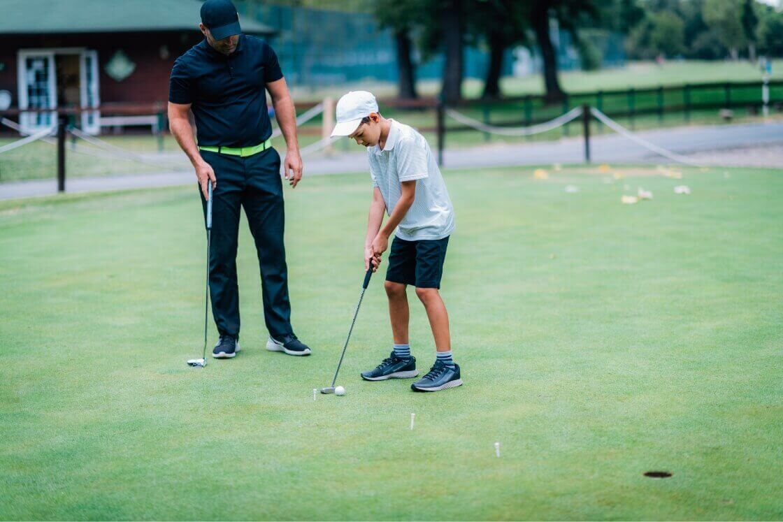 Vater mit Sohn am Golf spielen
