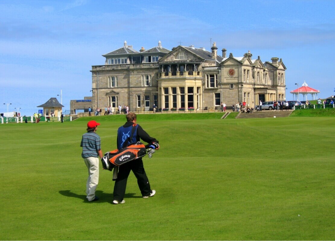 Ein Mann geht mit einem Teenager auf einem Golfplatz