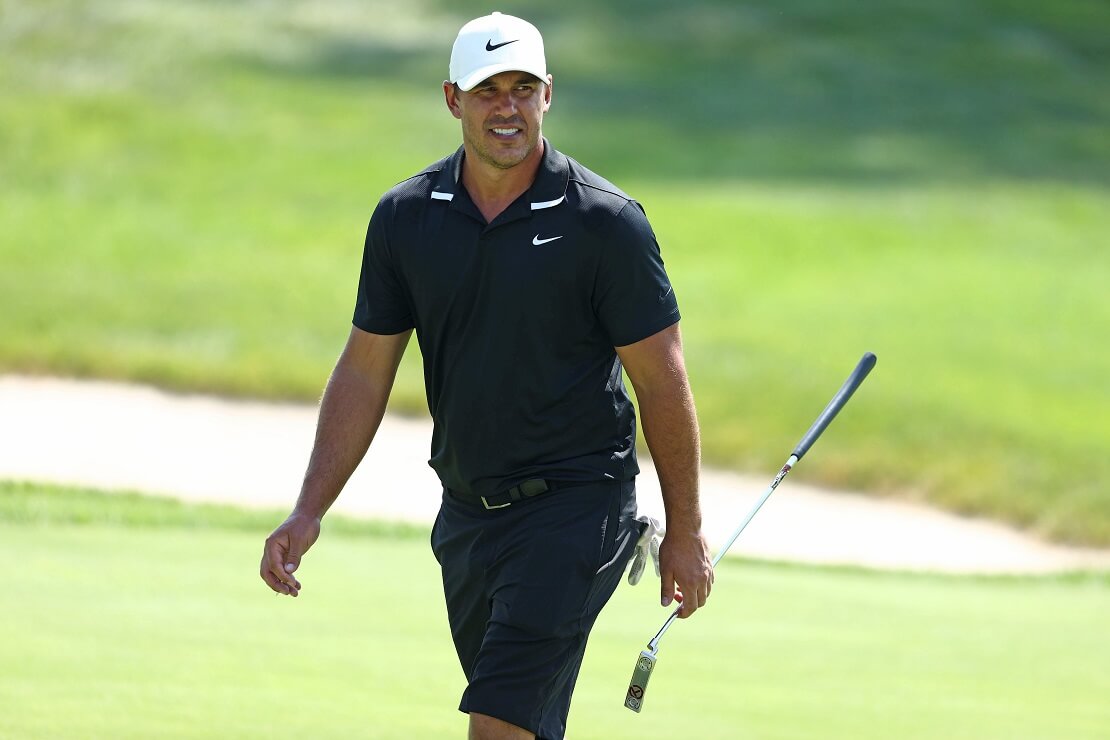 Brooks Koepka läuft mit seinem Schläger in der Hand über das Grün.