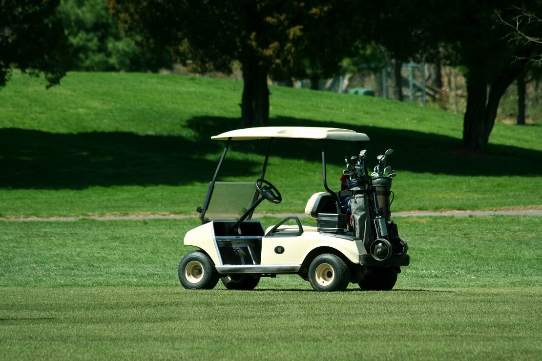 Ein auf dem Fairway geparktes Golfkart