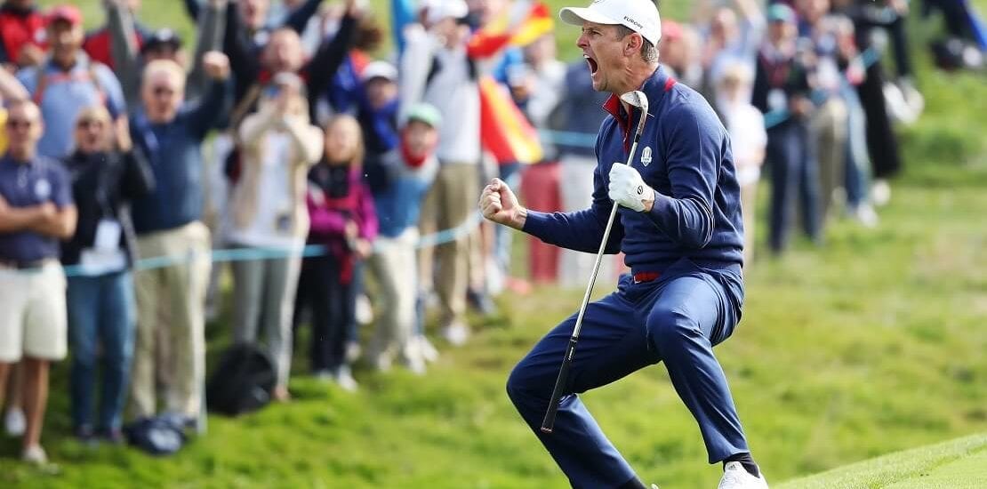 Justin Rose jubelt mit einem Golfschläger in der Hand vor Fans