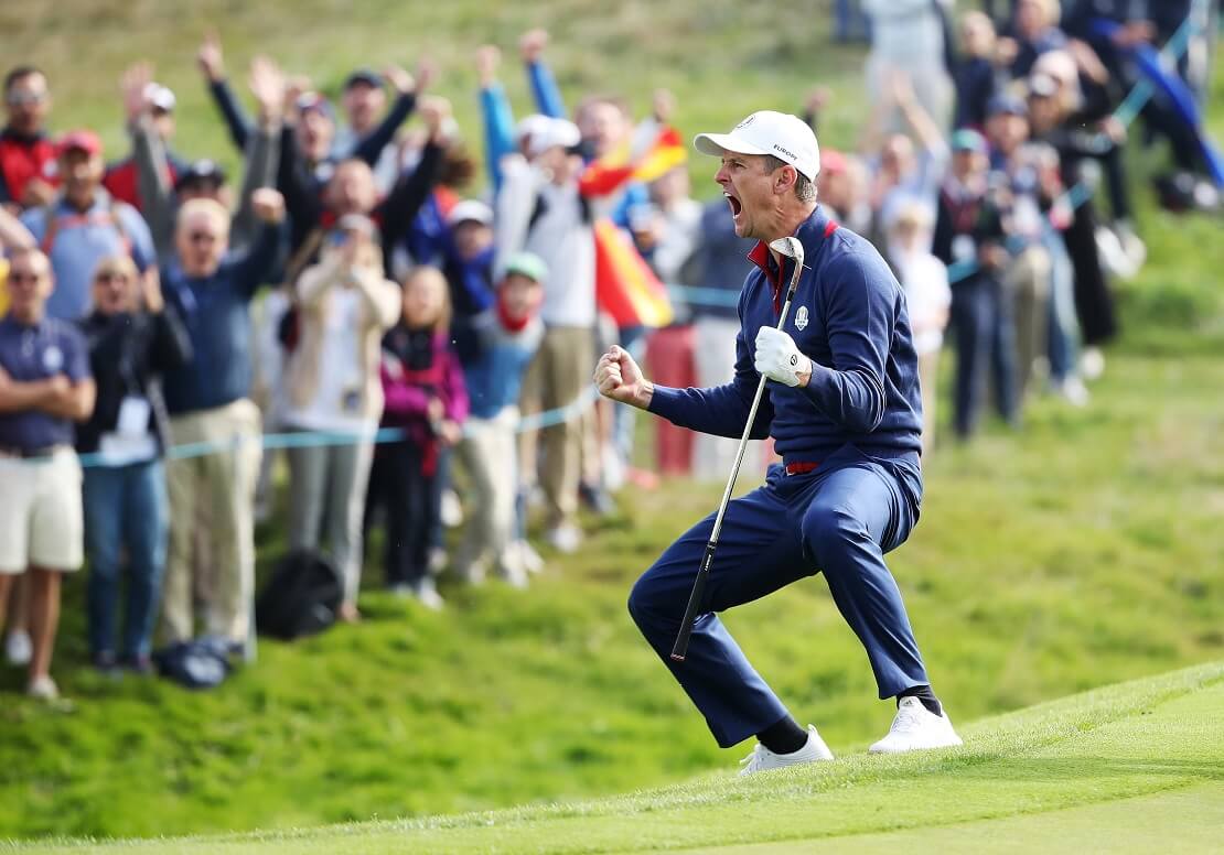 Justin Rose jubelt mit einem Golfschläger in der Hand vor Fans