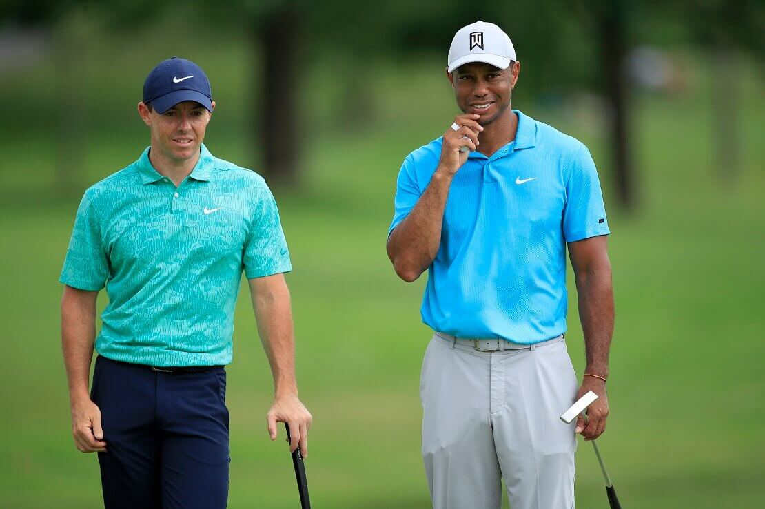 Rory Mc Ilroy und Tiger Woods stehen mit ihren Golfschlägern in den Händen nebeneinander