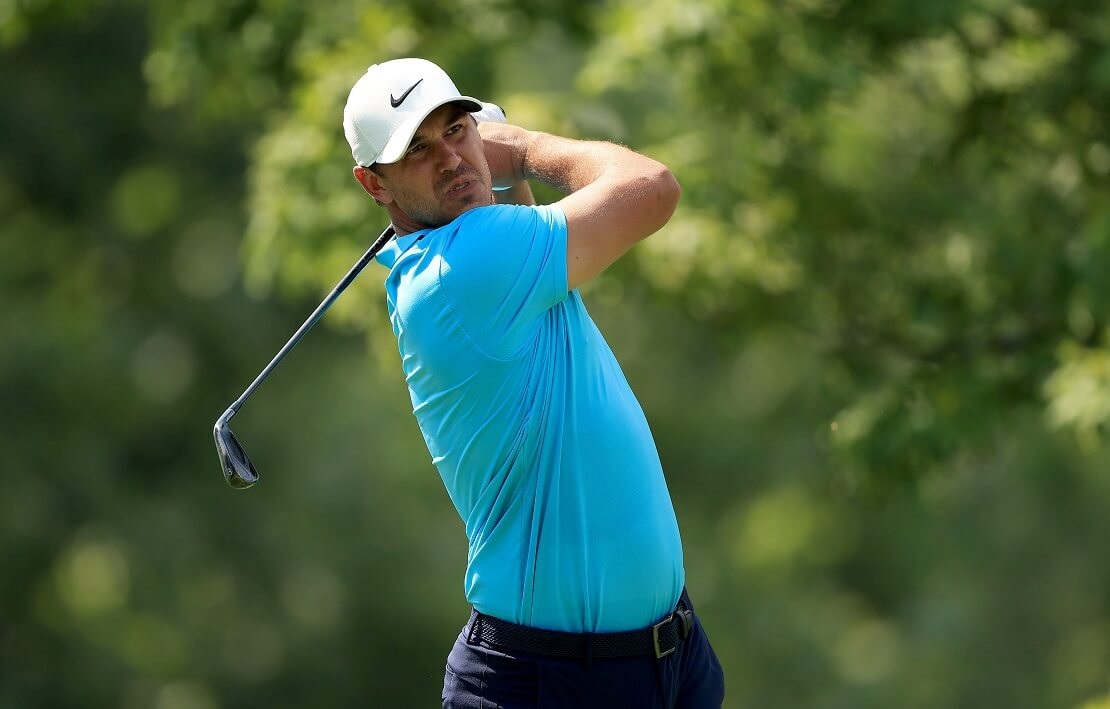 Brooks Koepka hält seinen Schläger nach dem Durchschwung hinter dem Rücken.