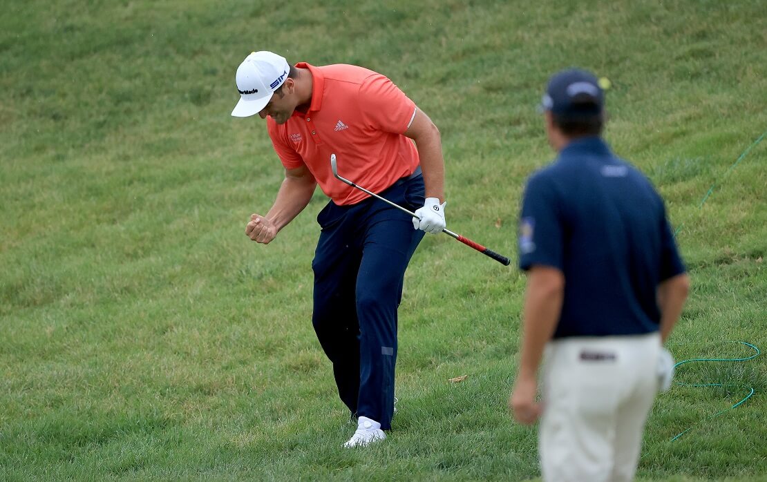 Jon Rahm freut sich auf dem Golfplatz mit einem Golfschläger in der Hand
