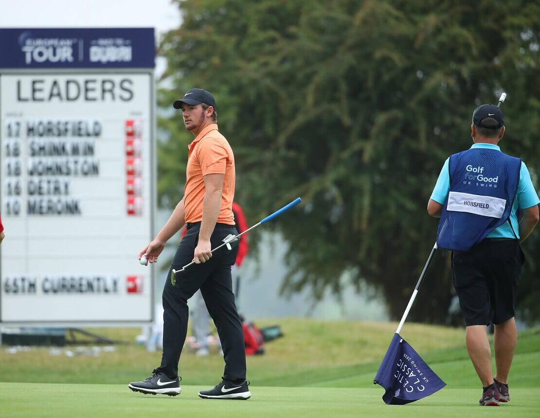 Sam Horsfield auf dem Grün vor einem Leaderboard der European Tour.