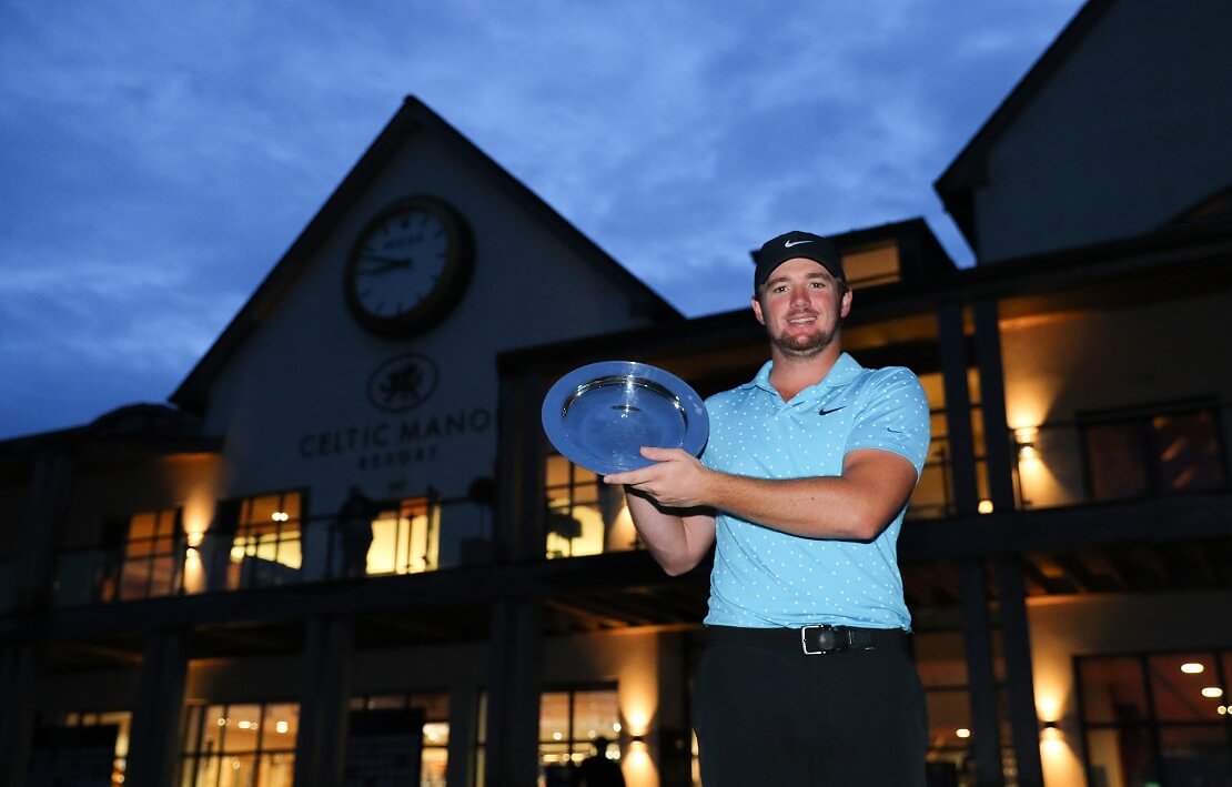 Sam Horsfield steht in der Dämmerung vor dem Celtic Manor Resort und hält die Trophäe der Celtic Classic