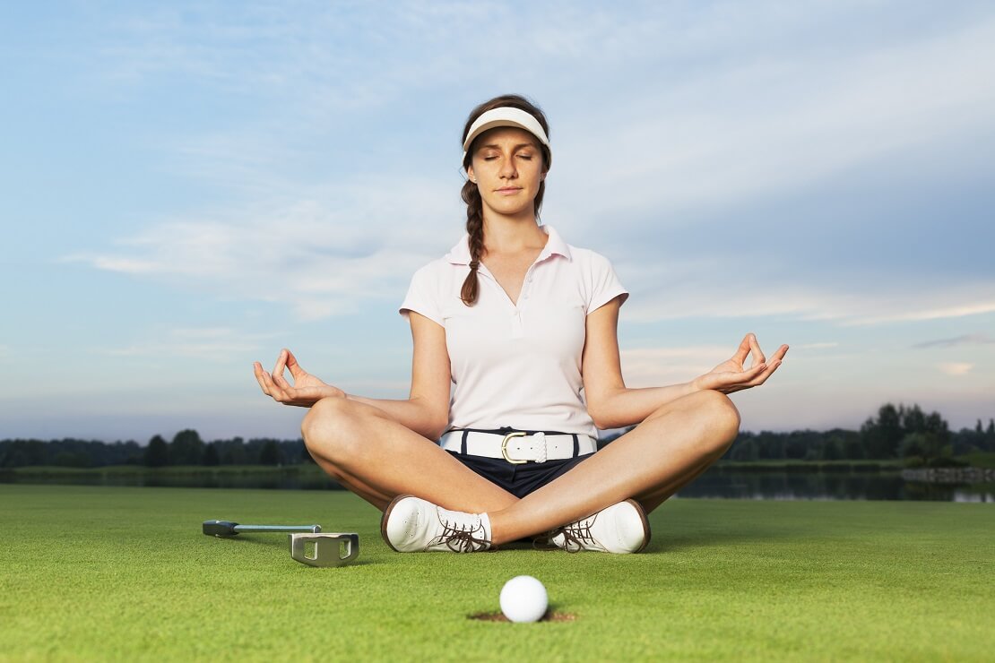 Frau Meditiert auf einem Golfplatz