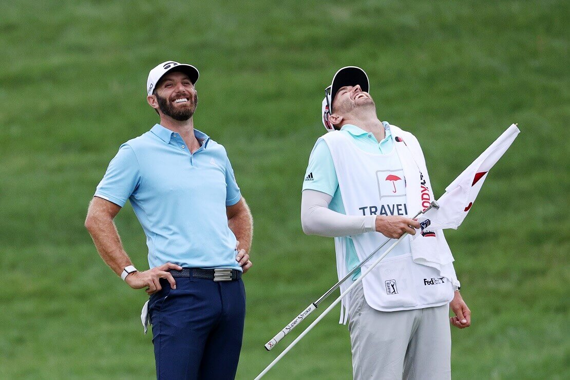 Dustin Johnson lacht mit seinem Caddy