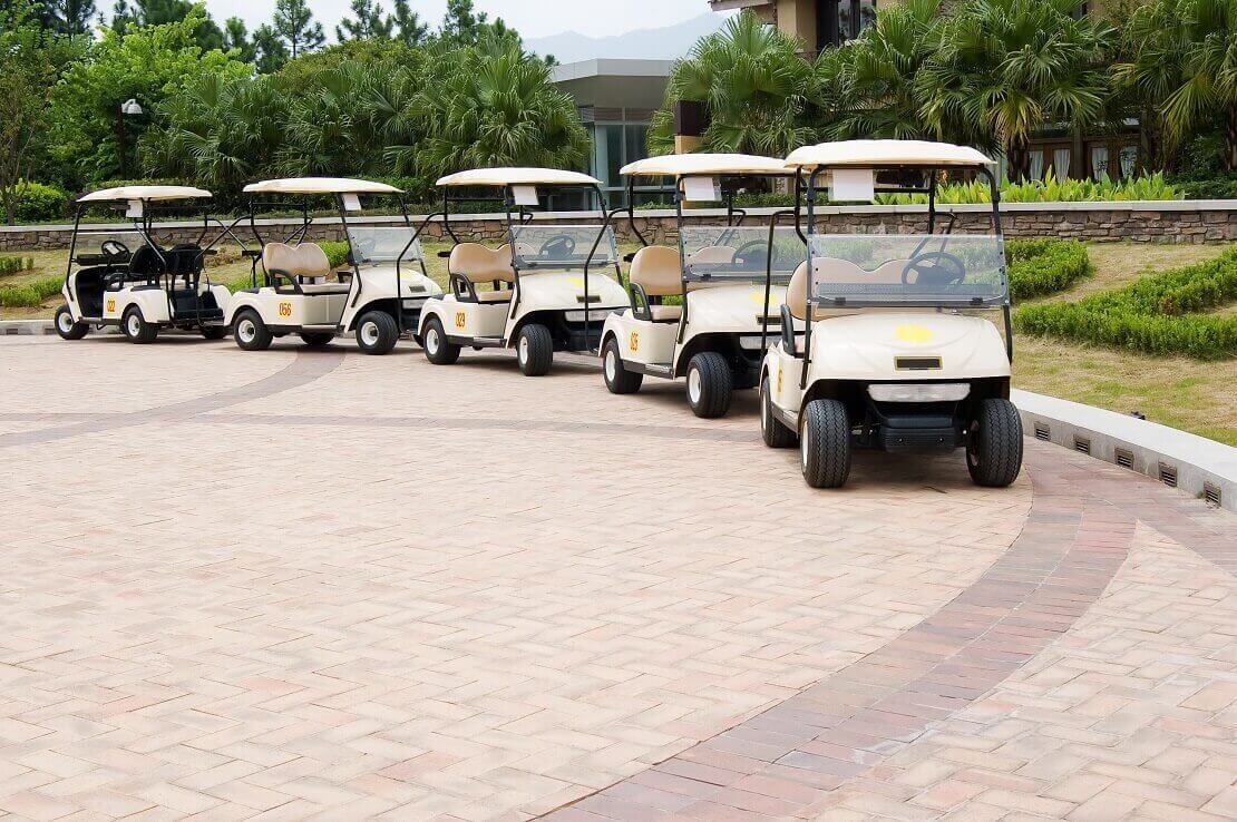 Leere aneinandergereihte Golfcarts in einem Golfclub