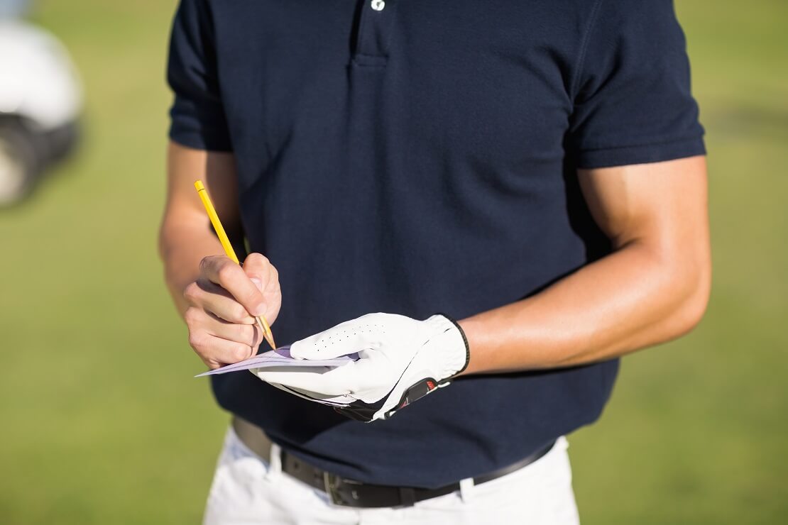 Golfer notiert seine Punkte auf einem Zettel