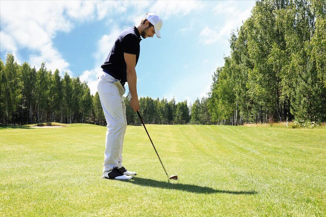 Golfer steht in der Ansprechposition auf dem Grün