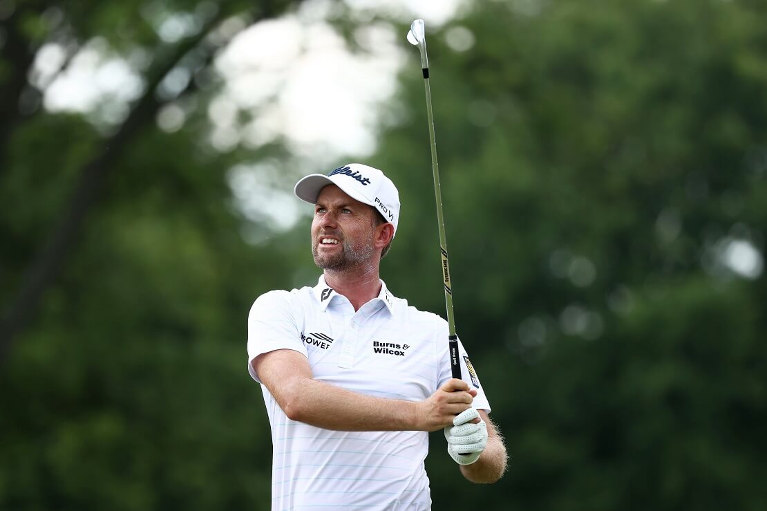 Webb Simpson mit einem Golfschläger in der Hand den er in die Luft hält