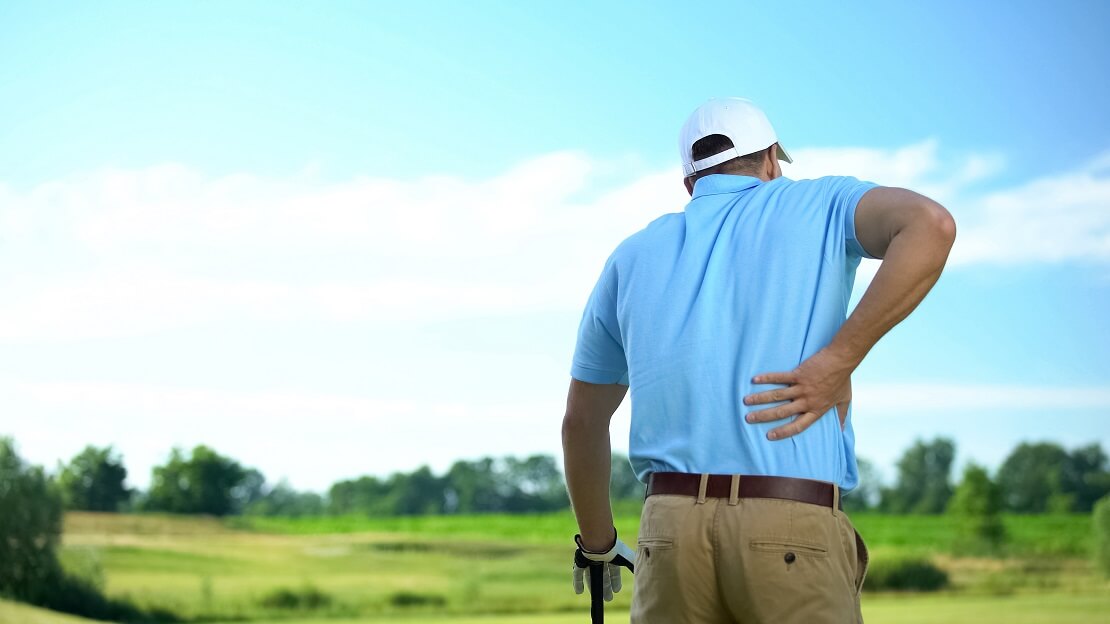 Golfer hält sich schmerzhaft den Rücken