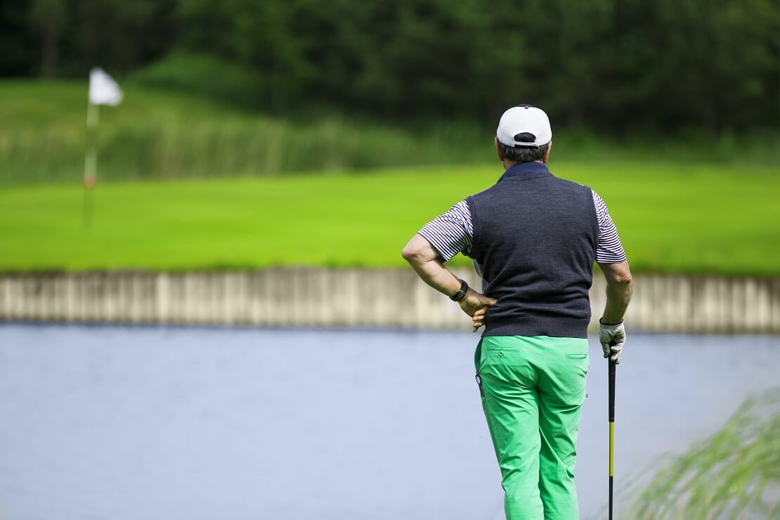 Golfer steht vor einem Wasserhindernis