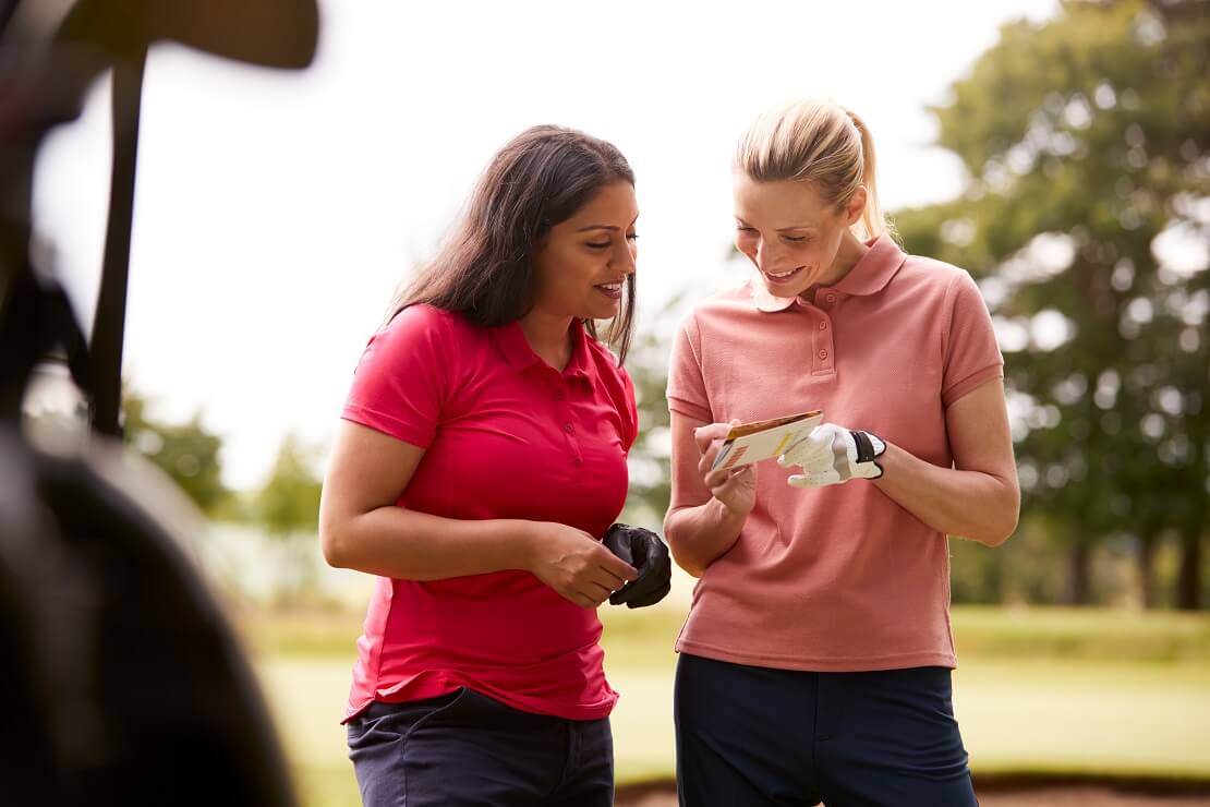 Zwei Golferinnen notieren ihre Ergebnisse auf der Scorekarte
