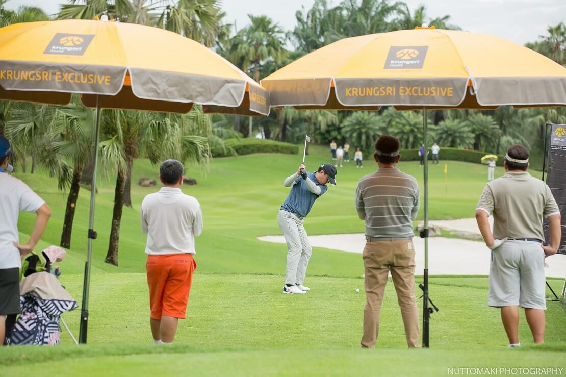 Golfer wird beim Abschlag eines Balles von Zuschauern beobachtet