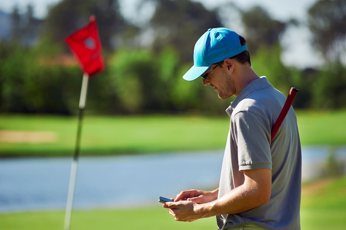 Golfer notiert sich sein Ergebnis in seinem Handy