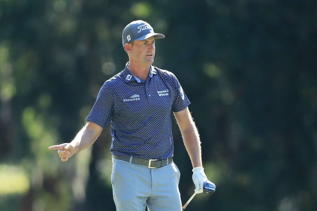 Webb Simpson zeigt mit seinem Zeigefinger nach rechts und hält seinen Schläger links