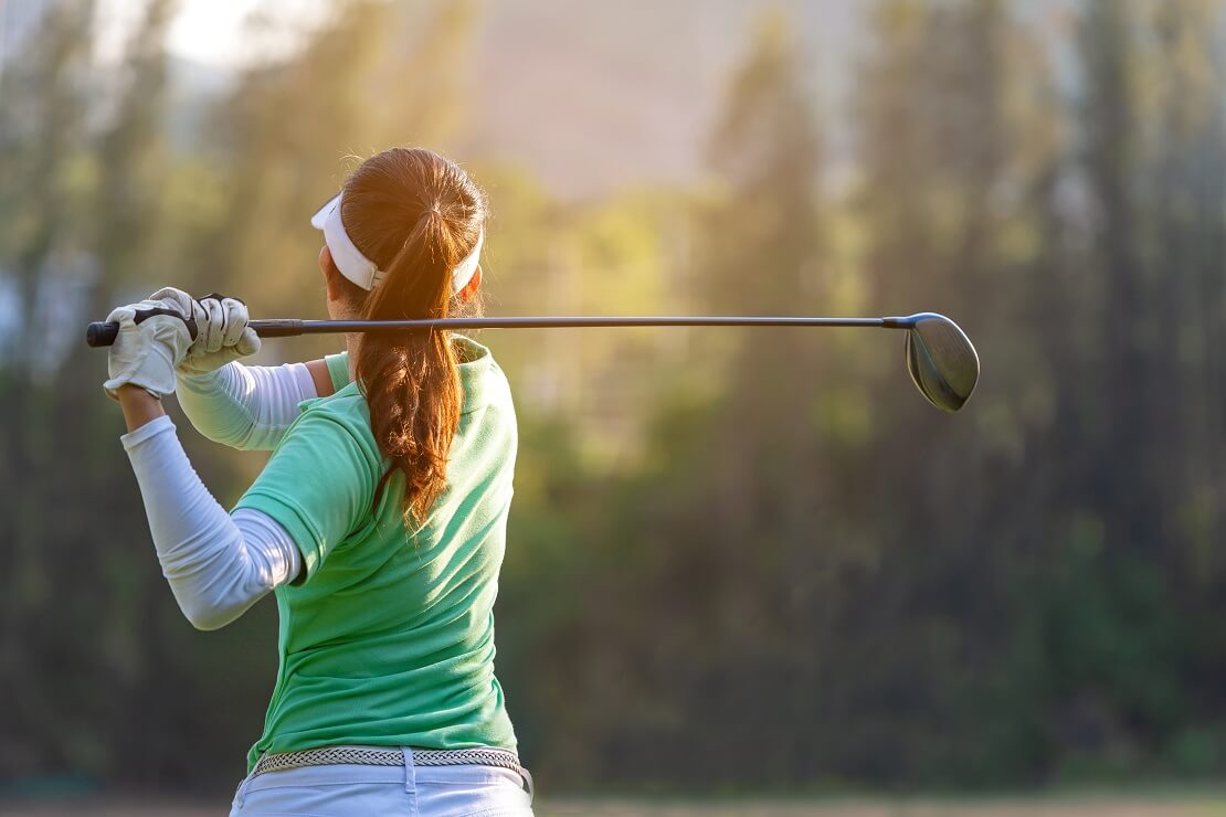 Golferin von hinten nach dem Abschlag