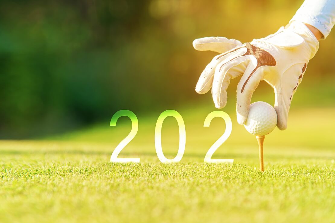 Golferin legt einen Ball auf das Tee und die Zahl 2020 entstehen