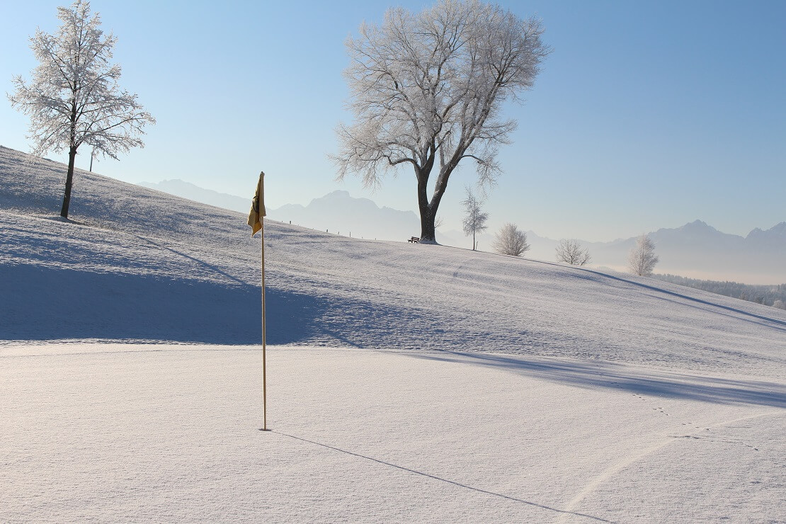 Golfplatz mit Schnee bedeckt und Fahne