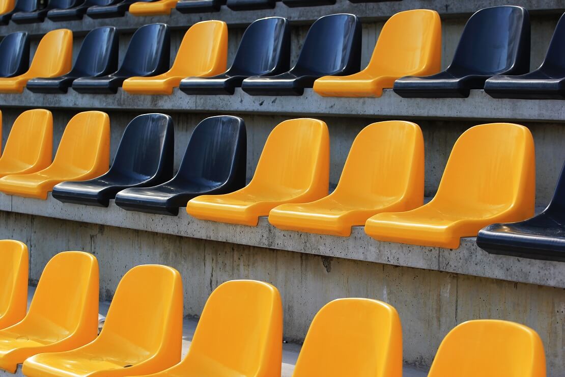 Leere gelbe und schwarze Sitze eines Stadions