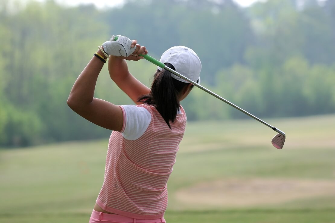 Golferin von hinten nach dem Abschlag