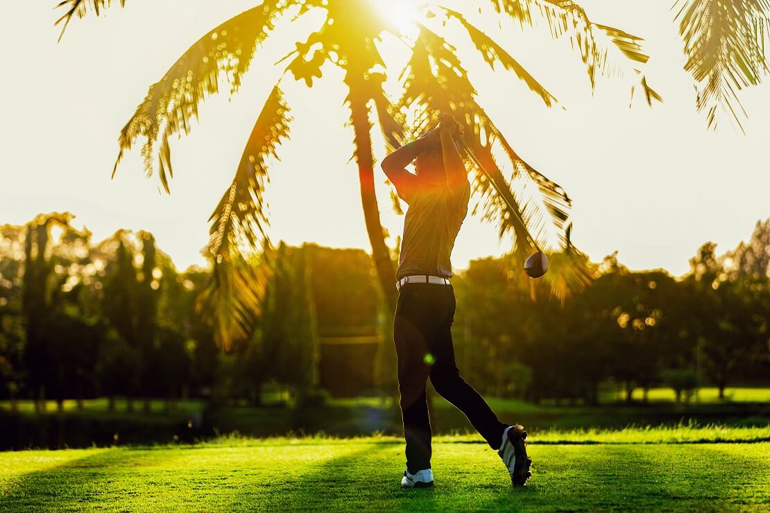 Golfer mit Palme und Sonne im Hintergrund