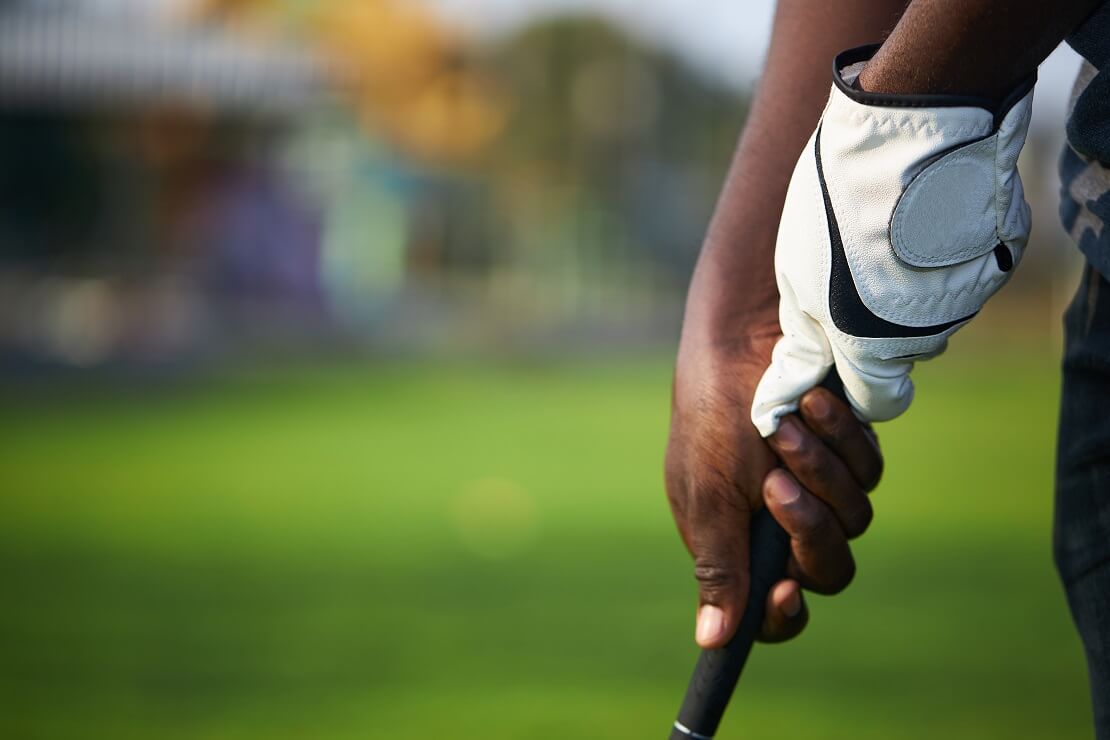 Golfer umgreift seinen Schläger mit einem Handschuh