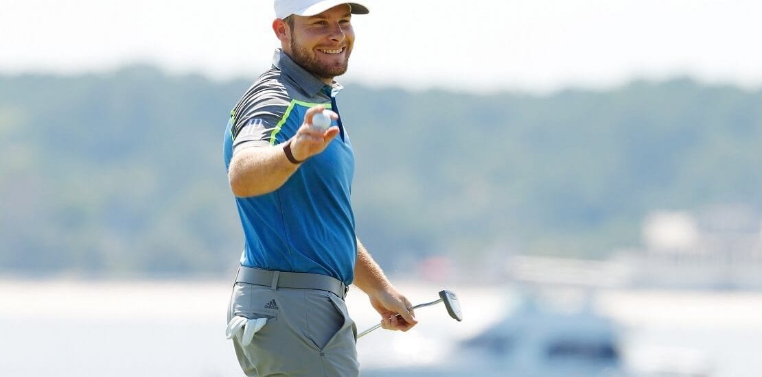 Tyrrell Hatton lächelt mit Schläger und Ball in der Hand