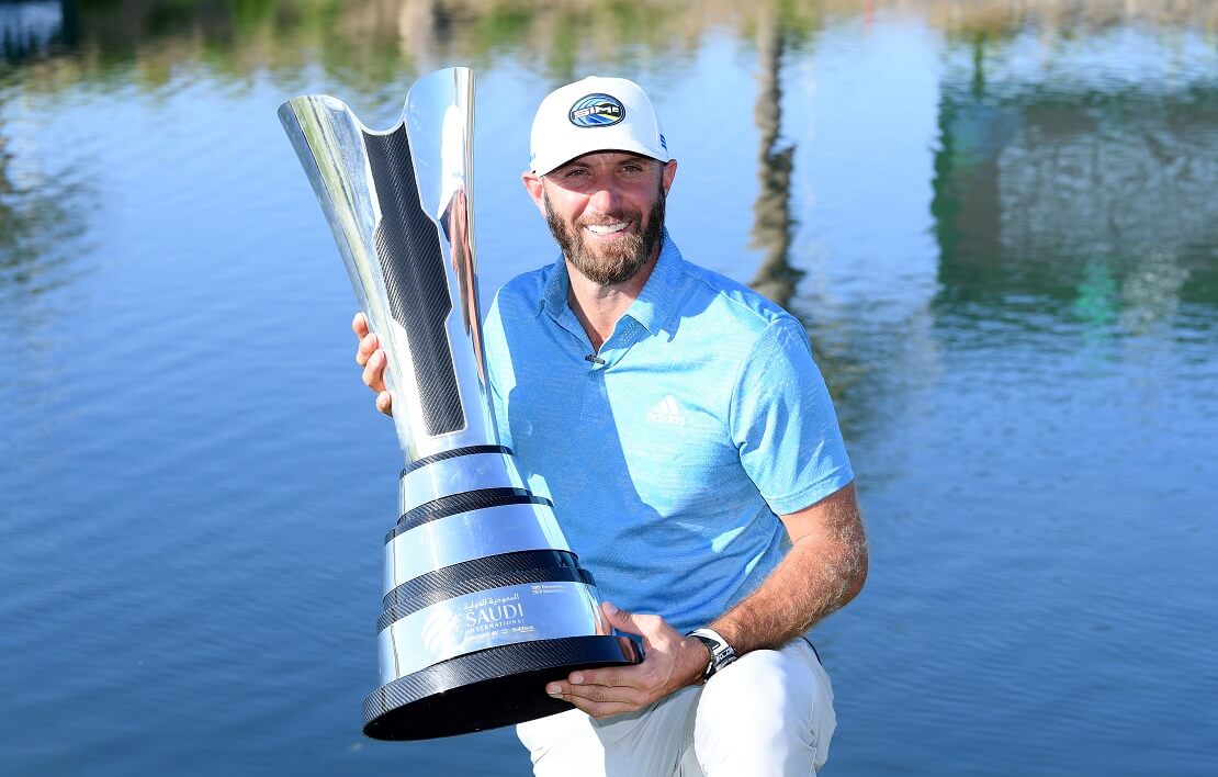 Dustin Johnson posiert mit der Trophäe der Saudi International vor einem Gewässer