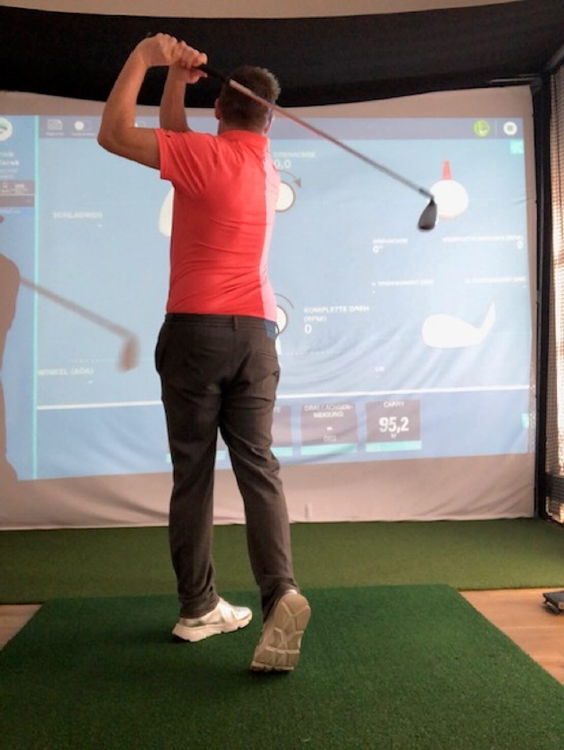 Golfer spielt mit einem Golfsimulator