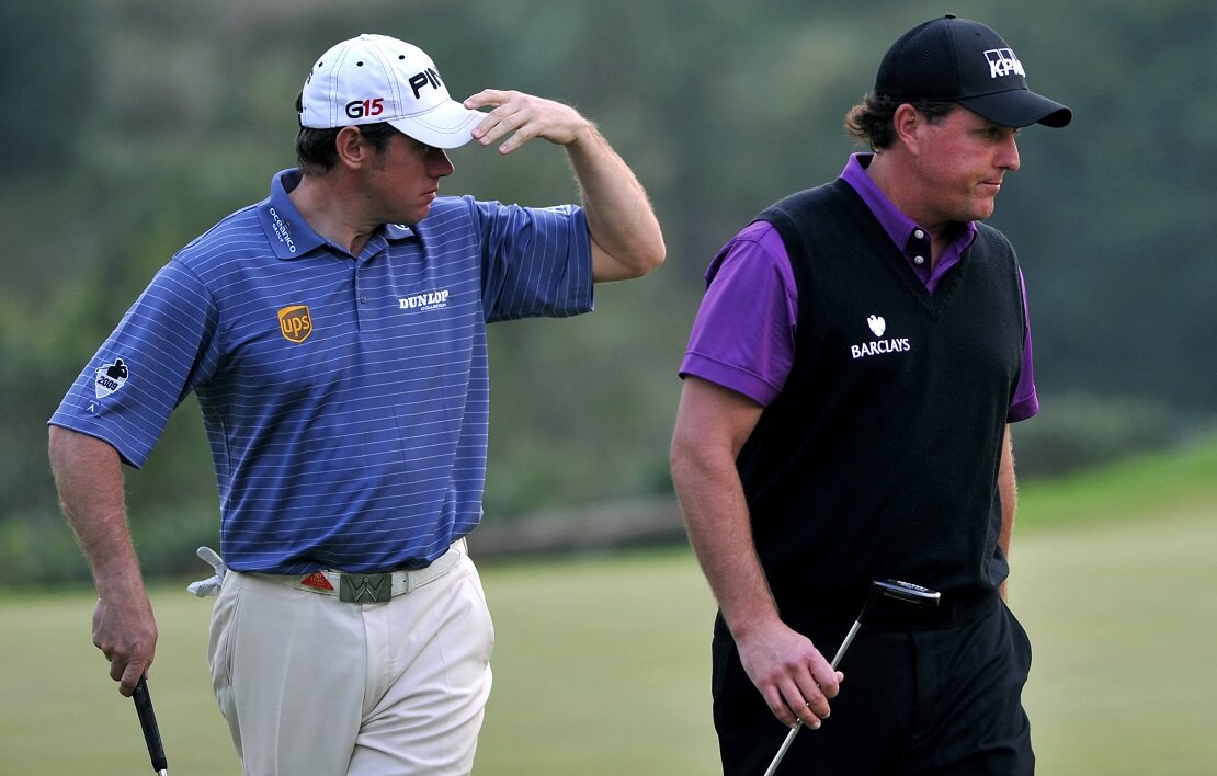 Lee Westwood und Phil Mickelson laufen mit Golfschlägern nebeneinander her