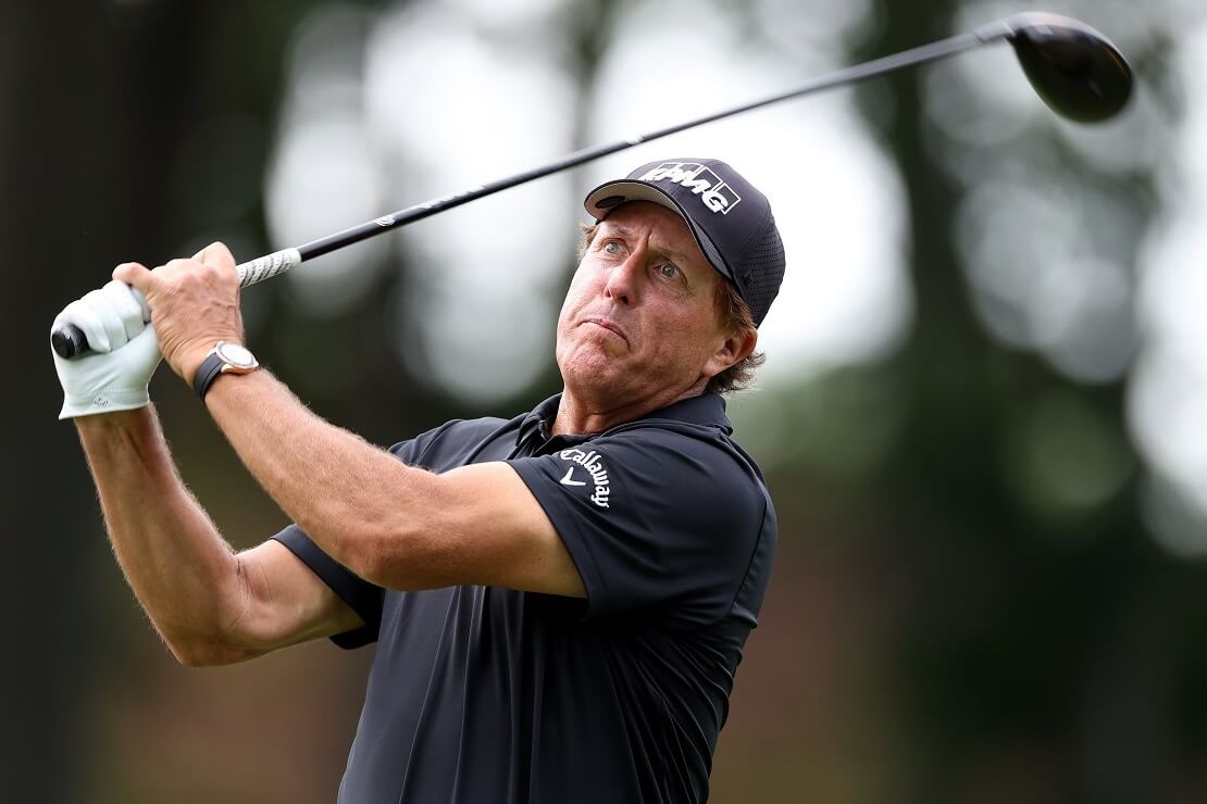 Phil Mickelson hält den Driver nach dem Abschlag oben und schaut seinem Ball hinterher