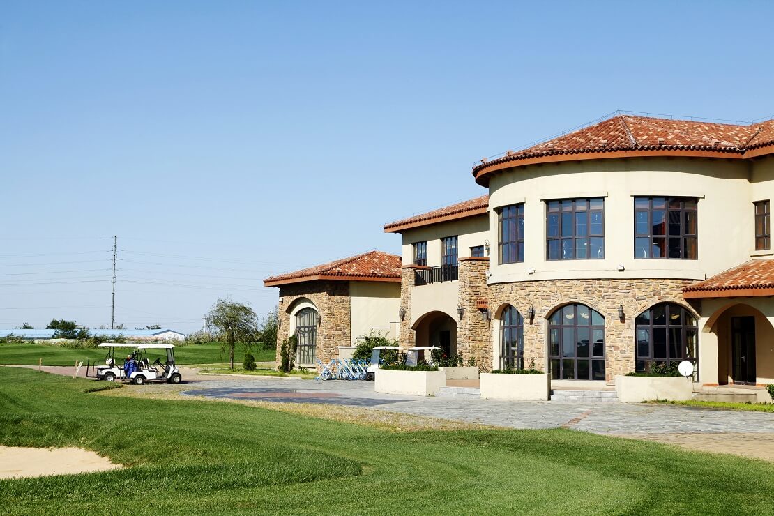 Clubhaus einer Golfanlage mit Golfcarts