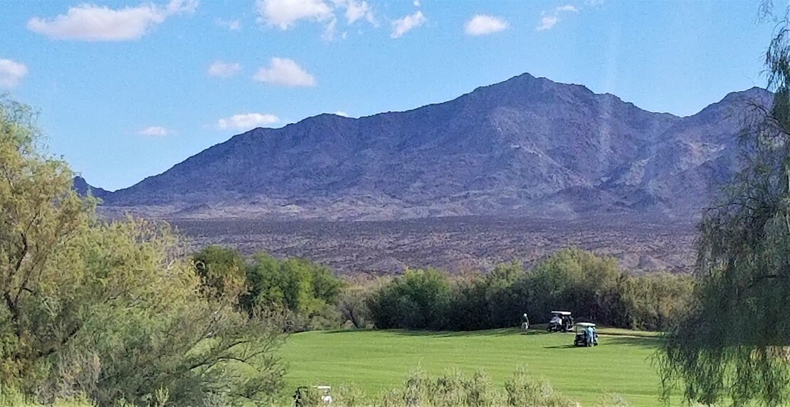 Golfkurs in der Wüste mit Bergen im Hintergrund