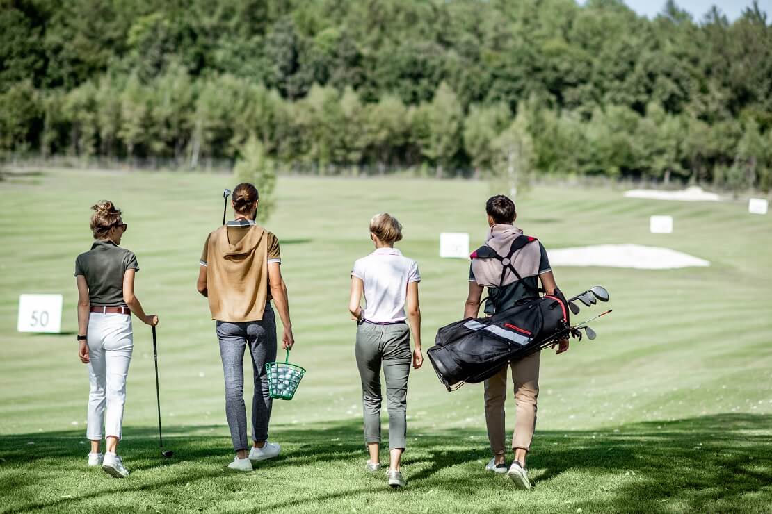 Gruppe Golfer läuft über den Golfplatz