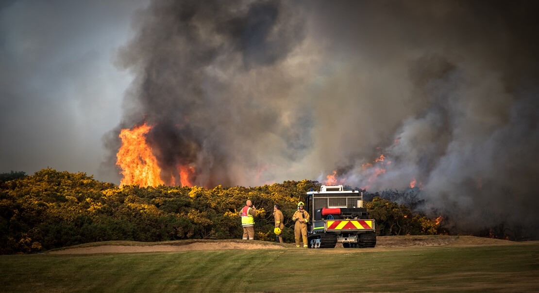 Golfplatz steht in Flammen und Feuerwehr versucht, zu löschen.