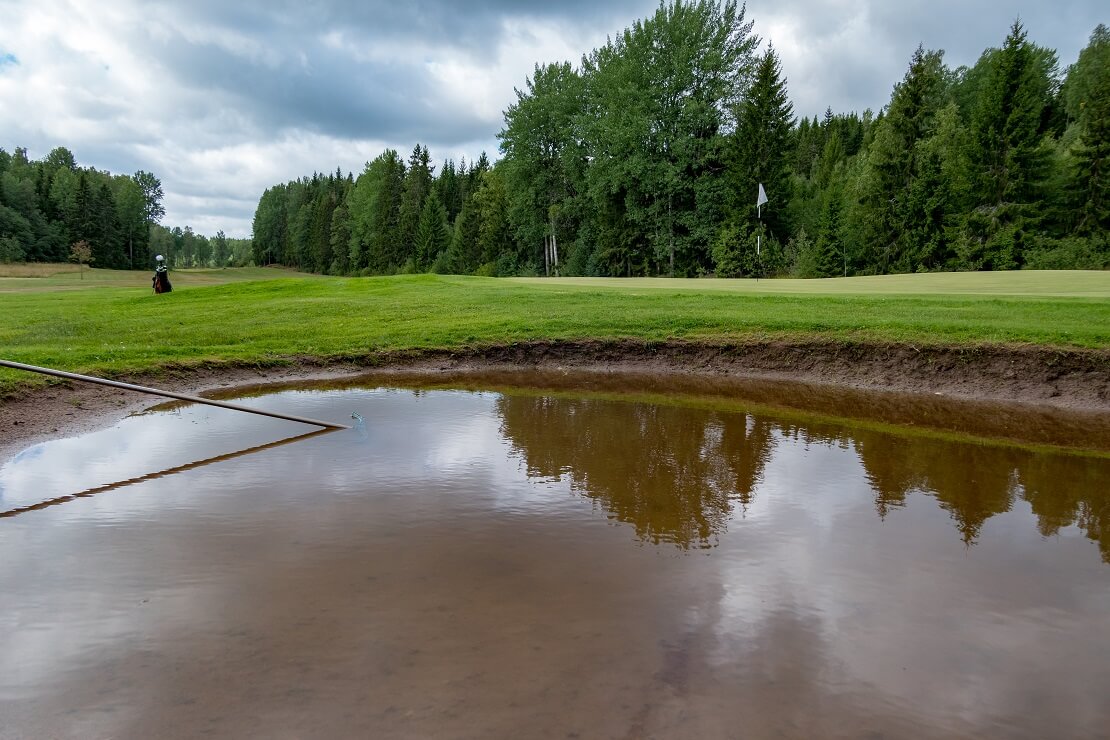 Bunker eines Golfplatzes voll mit Wasser