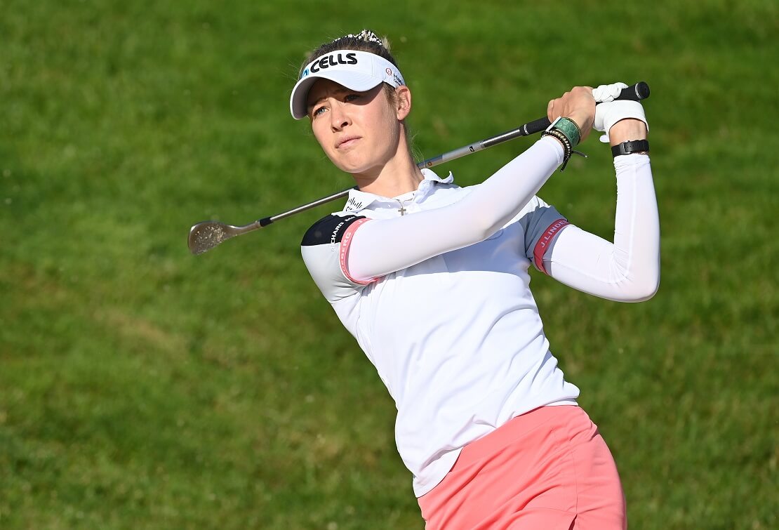 Nelly Korda hält den Schläger hinter dem Rücken