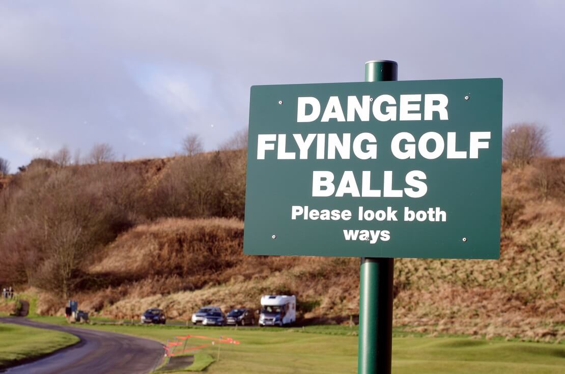 "Danger Flying Golf Balls" auf einem Schild