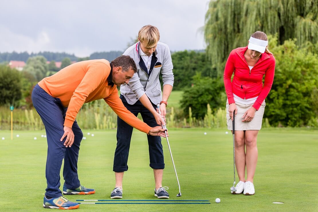 Golf Trainer mit Golferin und Golfer
