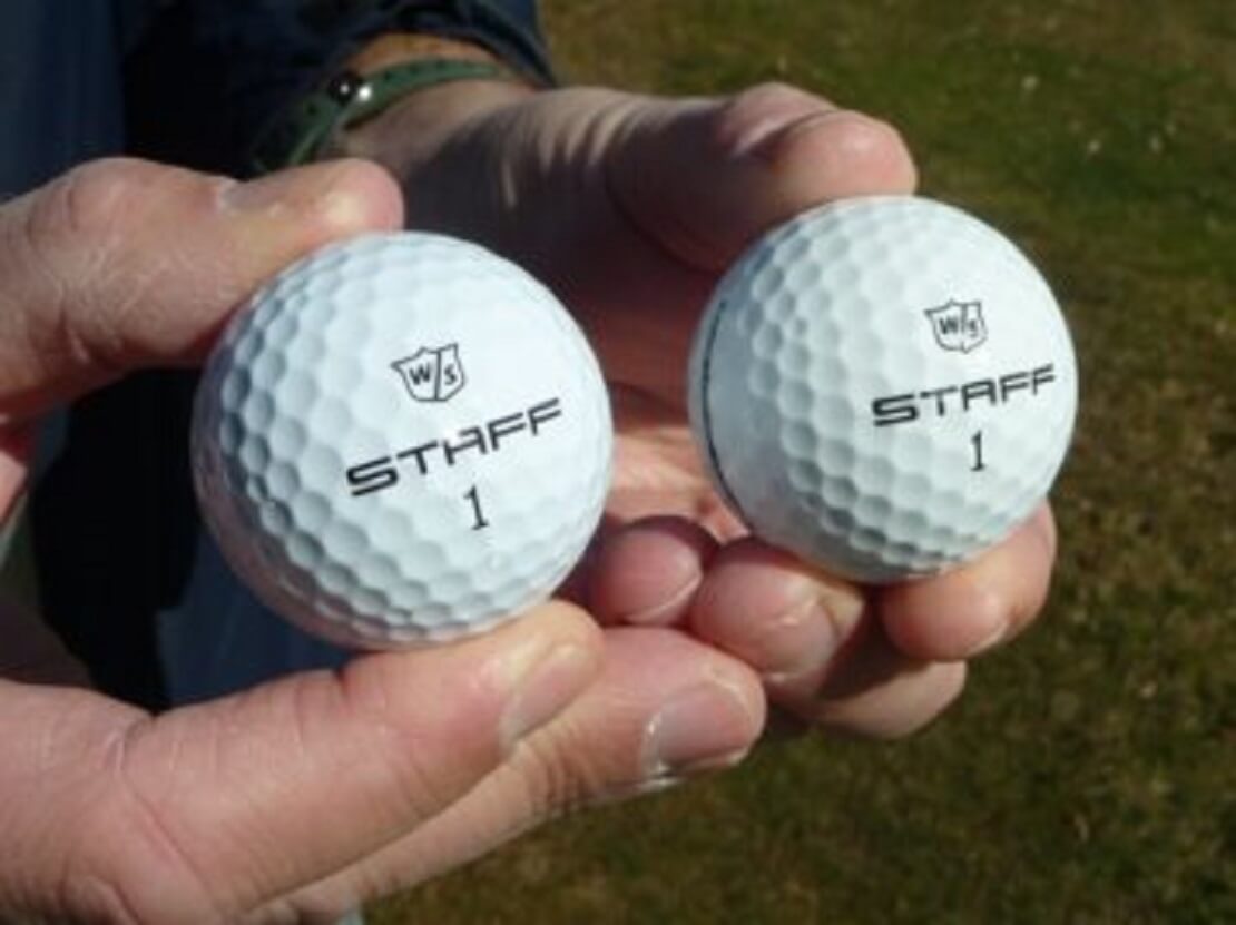 Zwei Golfbälle Wilson Staff Model R in Händen