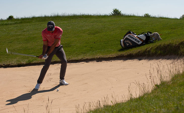 Bernd Ritthammer schlägt einen Ball aus dem Bunker