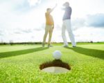 Golfspieler klatschen hinter einem Loch ein