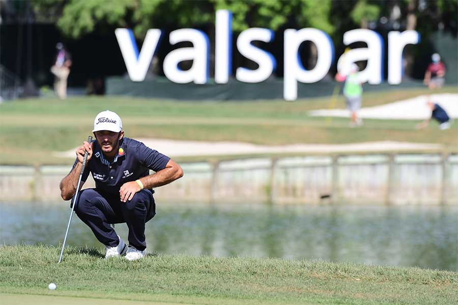 Max Homa in der Hocke mit seinem Golfschläger in der Hand