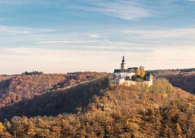 Eine Burg auf einem Hügel m Wald