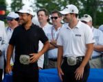 Zwei Golfer mit besonderen Gürtelschnallen bei der Siegerehrung