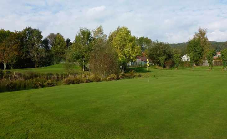 Ein Golfplatz mit Vereinsheim und Wasserhindernis